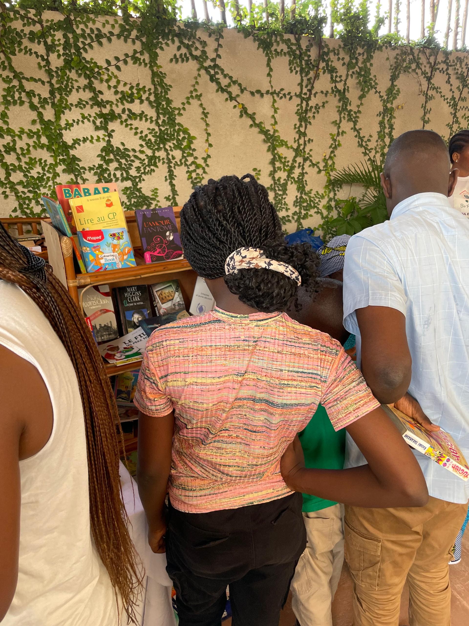 Visiteurs consultant une étagère de livres lors d'une exposition en plein air