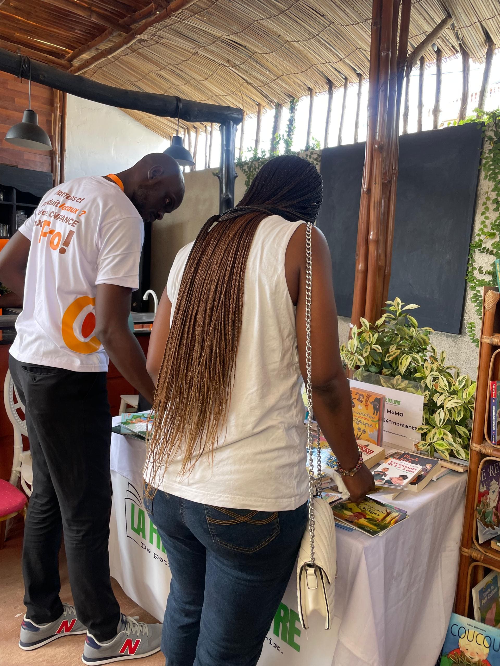 Client et cliente consultant les livres sur le stand La Friperie du Livre